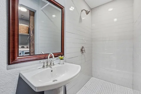 a bathroom with a sink a shower and a mirror