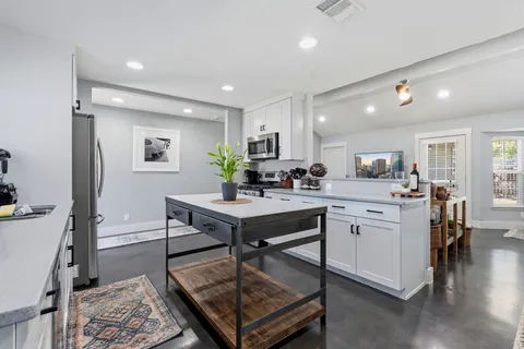 a kitchen with a table chairs refrigerator and microwave