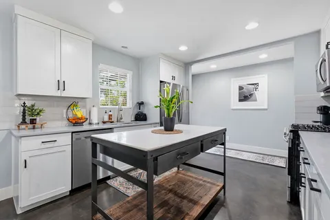 a view of a kitchen with a table and chairs in it