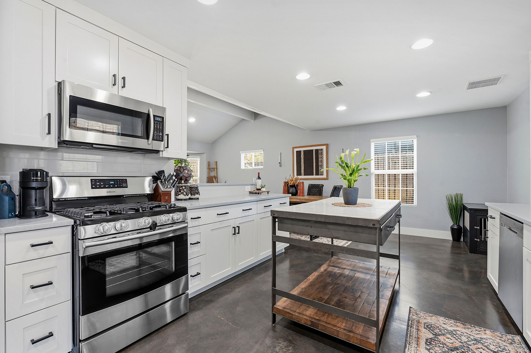 805 Nile Street Austin, TX 78702 - Photo 8 of 22 a kitchen with stainless steel appliances granite countertop a stove top oven a sink dishwasher and white cabinets with wooden floor