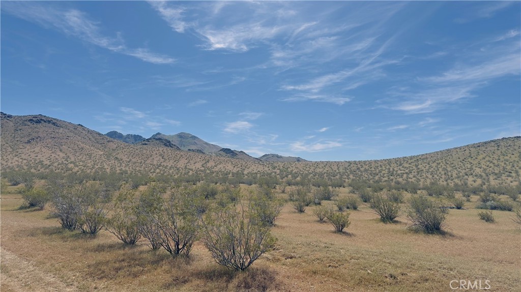 0 Near Caspar Road Apple Valley, CA 92307 - Photo 2 of 7 a view of a dry yard with mountains in the background