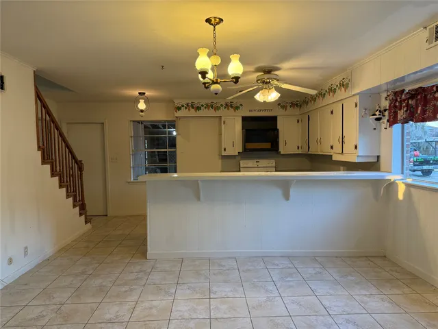 a view of a kitchen with a sink and chandelier