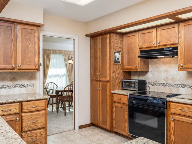 a kitchen with stainless steel appliances granite countertop a stove top oven a sink and cabinets