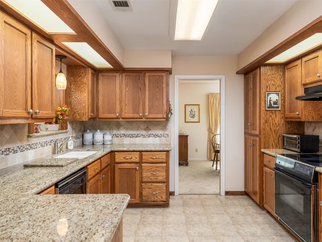 a kitchen with stainless steel appliances granite countertop a stove a sink and a microwave
