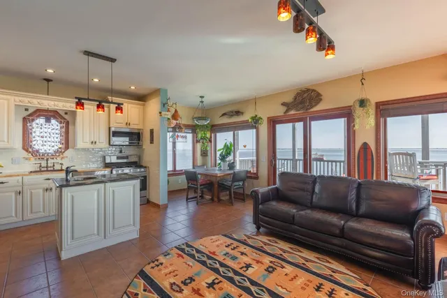 a living room with furniture a large window and appliances