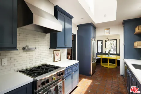 a kitchen with stainless steel appliances a stove a sink and a refrigerator