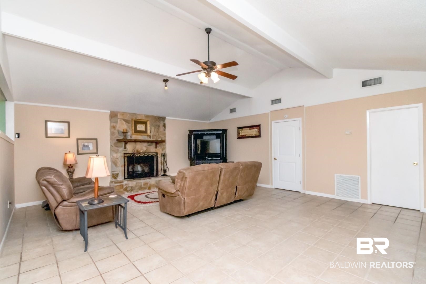 1321 Rainbow Drive West Mobile, AL 36693 - Photo 13 of 48 Tiled living room featuring lofted ceiling with beams, a stone fireplace, and ceiling fan