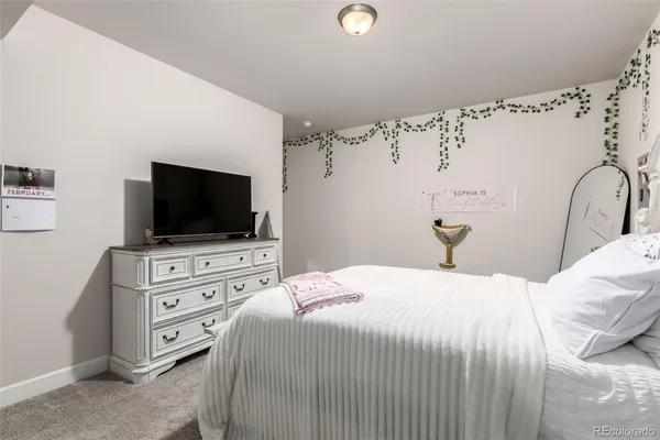 a bedroom with a flat screen tv on the dresser and a flat screen tv