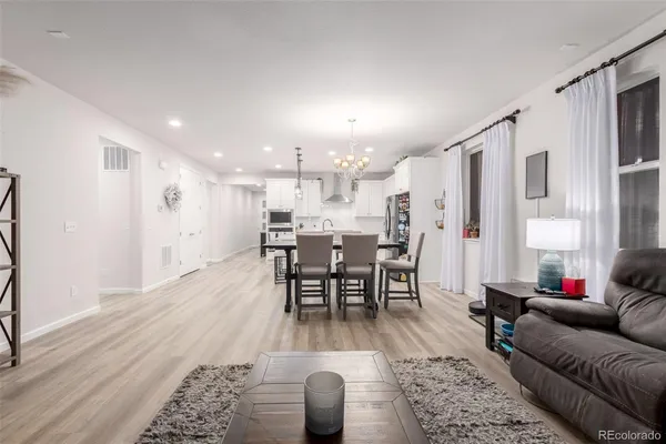 a living room with furniture a dining table and kitchen view