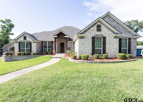 a front view of a house with yard and green space