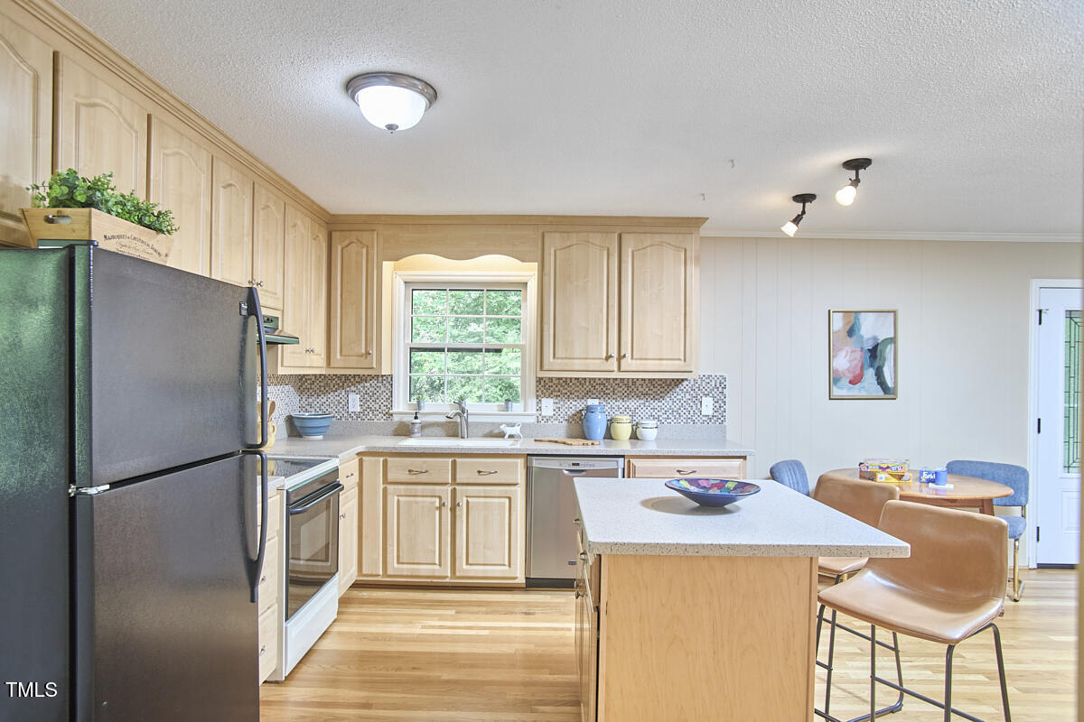 5319 Memory Lane Durham, NC 27712 - Photo 11 of 29 a kitchen with stainless steel appliances granite countertop a refrigerator a sink dishwasher a stove with white cabinets and wooden floor