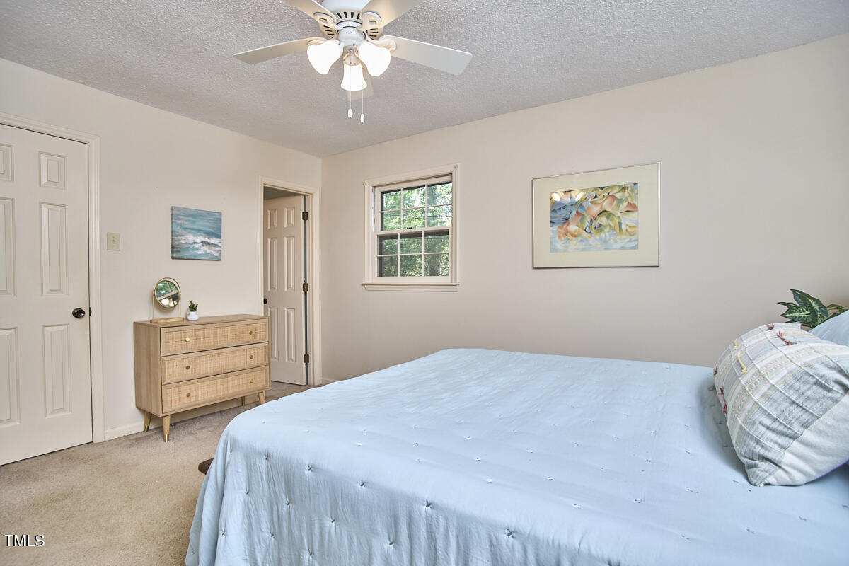 5319 Memory Lane Durham, NC 27712 - Photo 17 of 29 a bedroom with a bed and a chandelier
