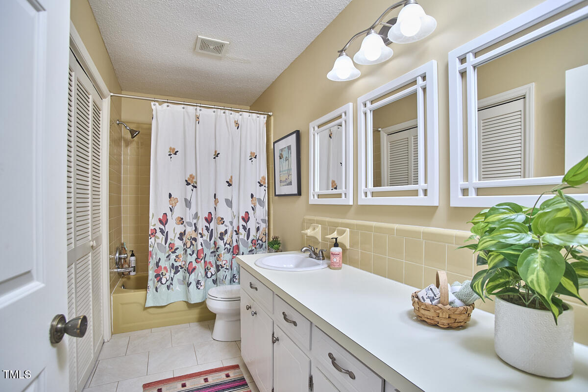 5319 Memory Lane Durham, NC 27712 - Photo 19 of 29 a bathroom with a granite countertop sink a toilet and a shower