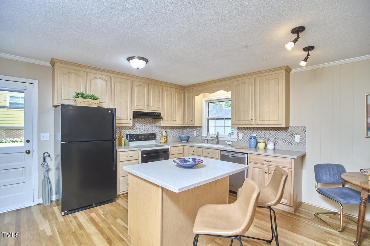 5319 Memory Lane Durham, NC 27712 - Photo 9 of 29 a kitchen with a refrigerator a stove a sink and dishwasher with wooden floor