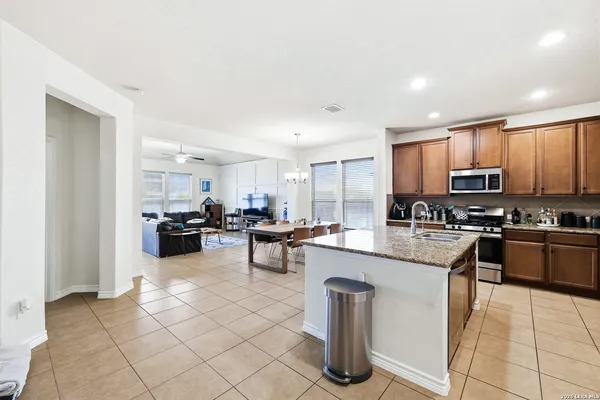 a kitchen with stainless steel appliances kitchen island granite countertop a sink and cabinets