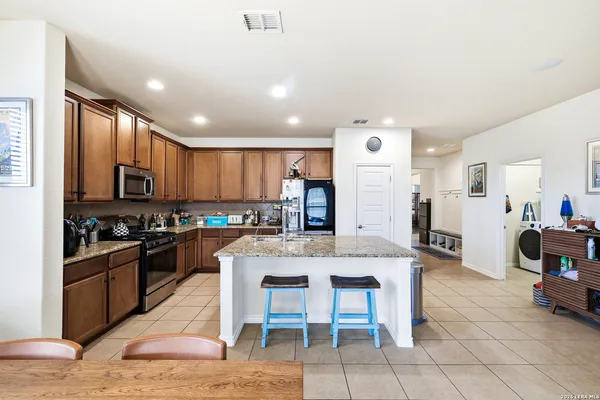 a large kitchen with cabinets table and chairs