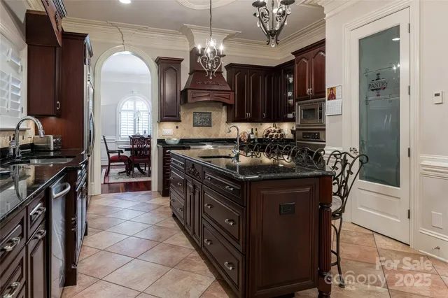 a kitchen with stainless steel appliances granite countertop a stove a sink and a refrigerator