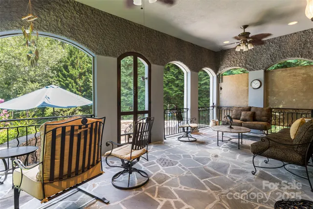 a living room with furniture a floor to ceiling window and a chandelier
