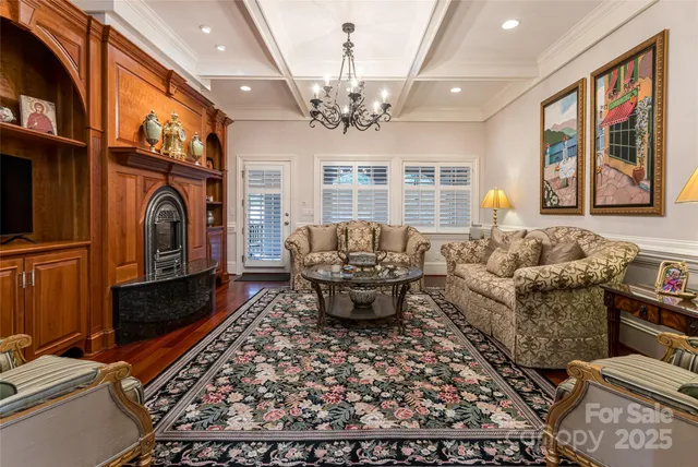 a living room with furniture a chandelier and a fireplace