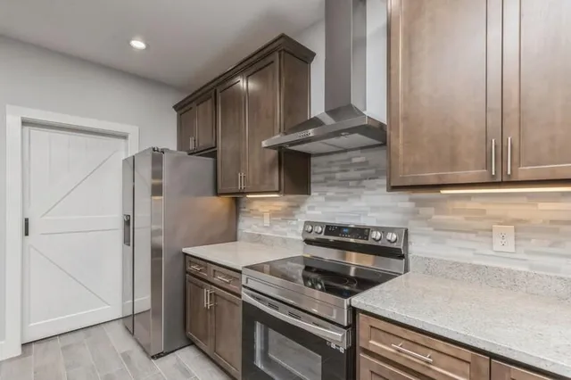 a kitchen with granite countertop a stove and a refrigerator