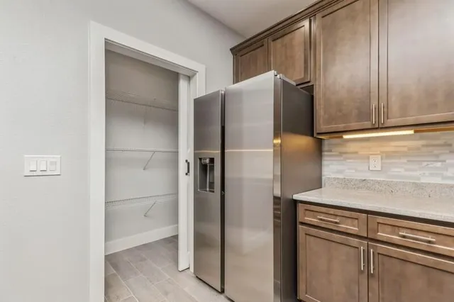 a metallic refrigerator freezer sitting in a kitchen
