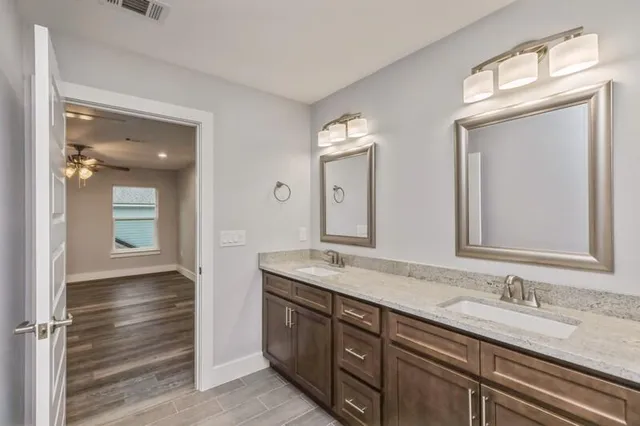 a bathroom with double sink and a mirror