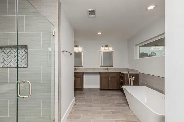 a large bathroom with a tub sink shower and mirror