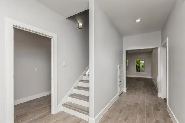 a view of a hallway with wooden floor and entryway