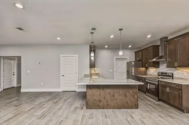 a large kitchen with stainless steel appliances kitchen island granite countertop a large counter top and stove