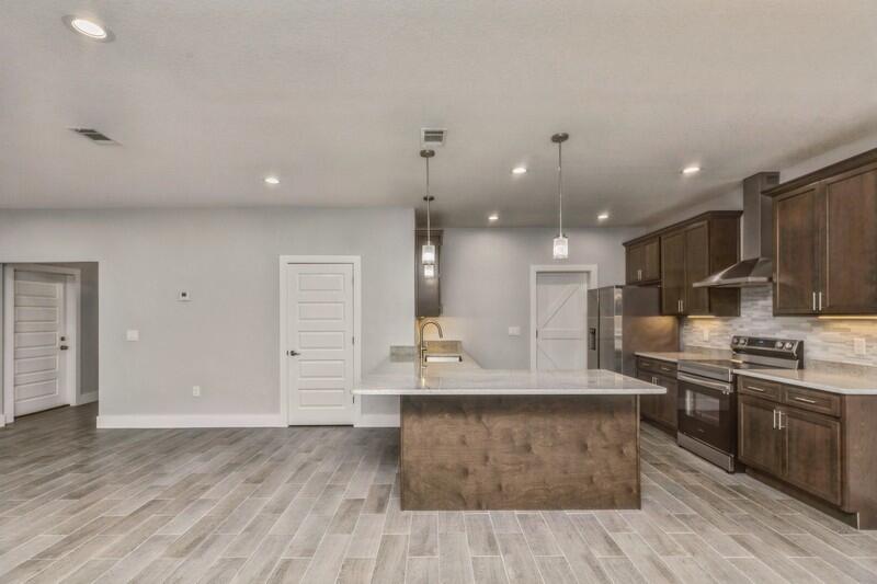 4516 Hermosa Road Crestview, FL 32539 - Photo 8 of 35 a large kitchen with stainless steel appliances kitchen island granite countertop a large counter top and stove