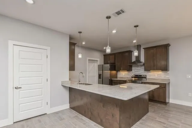 a kitchen with kitchen island a sink stainless steel appliances and cabinets