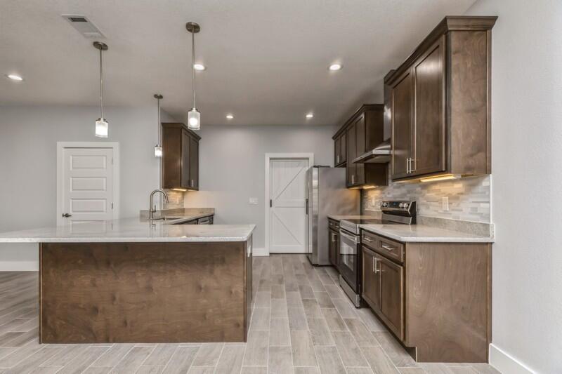 4516 Hermosa Road Crestview, FL 32539 - Photo 10 of 35 a kitchen with stainless steel appliances granite countertop a sink a stove and a wooden floors