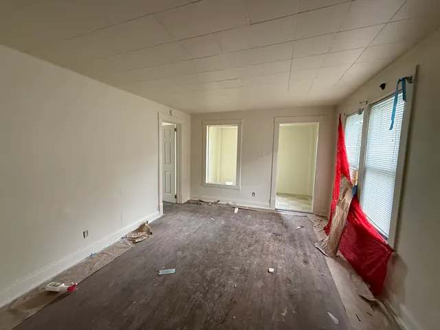 an empty room with windows and closet