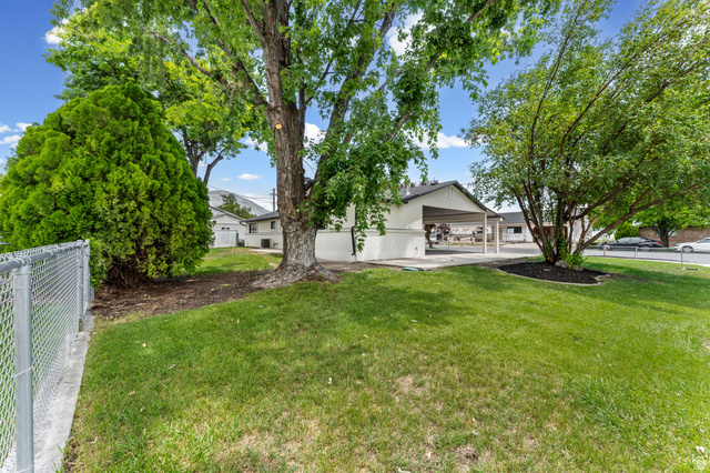 1898 West 600 South Provo, UT 84601 - Photo 30 of 32 Expansive green lawn with mature trees and a chain-link fence