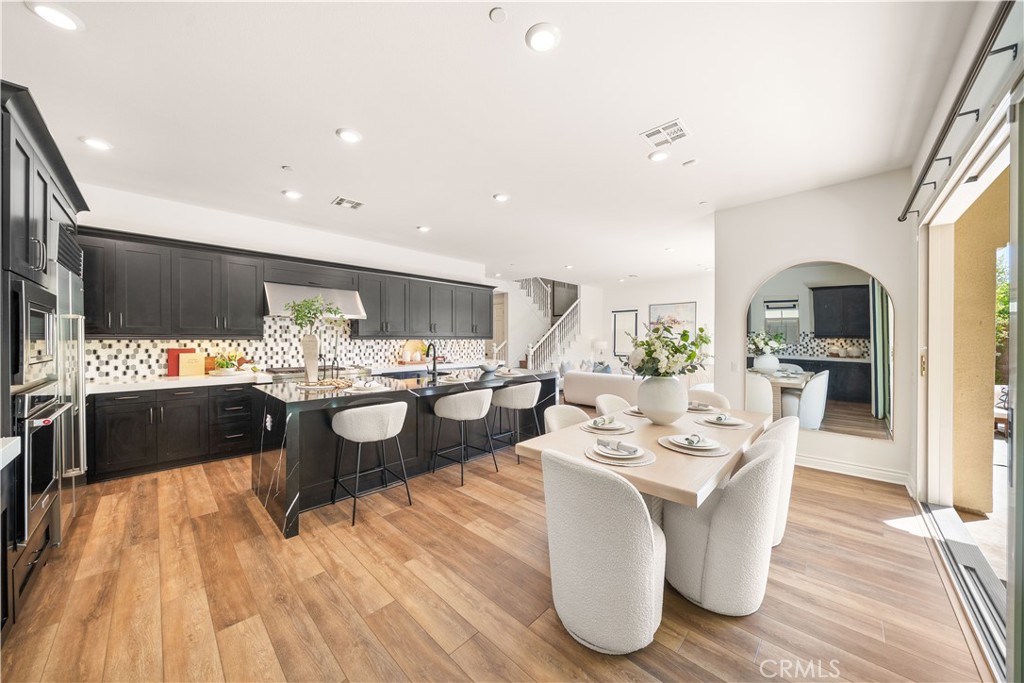 143 Ceremony Irvine, CA 92618 - Photo 13 of 74 a living room with stainless steel appliances kitchen island granite countertop wooden floor a dining table and chairs