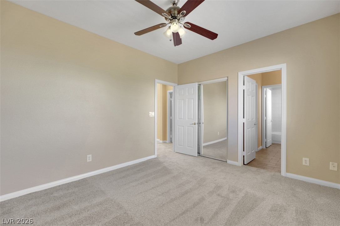 10328 Hawk Ravine Street Las Vegas, NV 89178 - Photo 36 of 55 A well-lit bedroom features plush carpeting and a convenient ceiling fan for ultimate comfort.