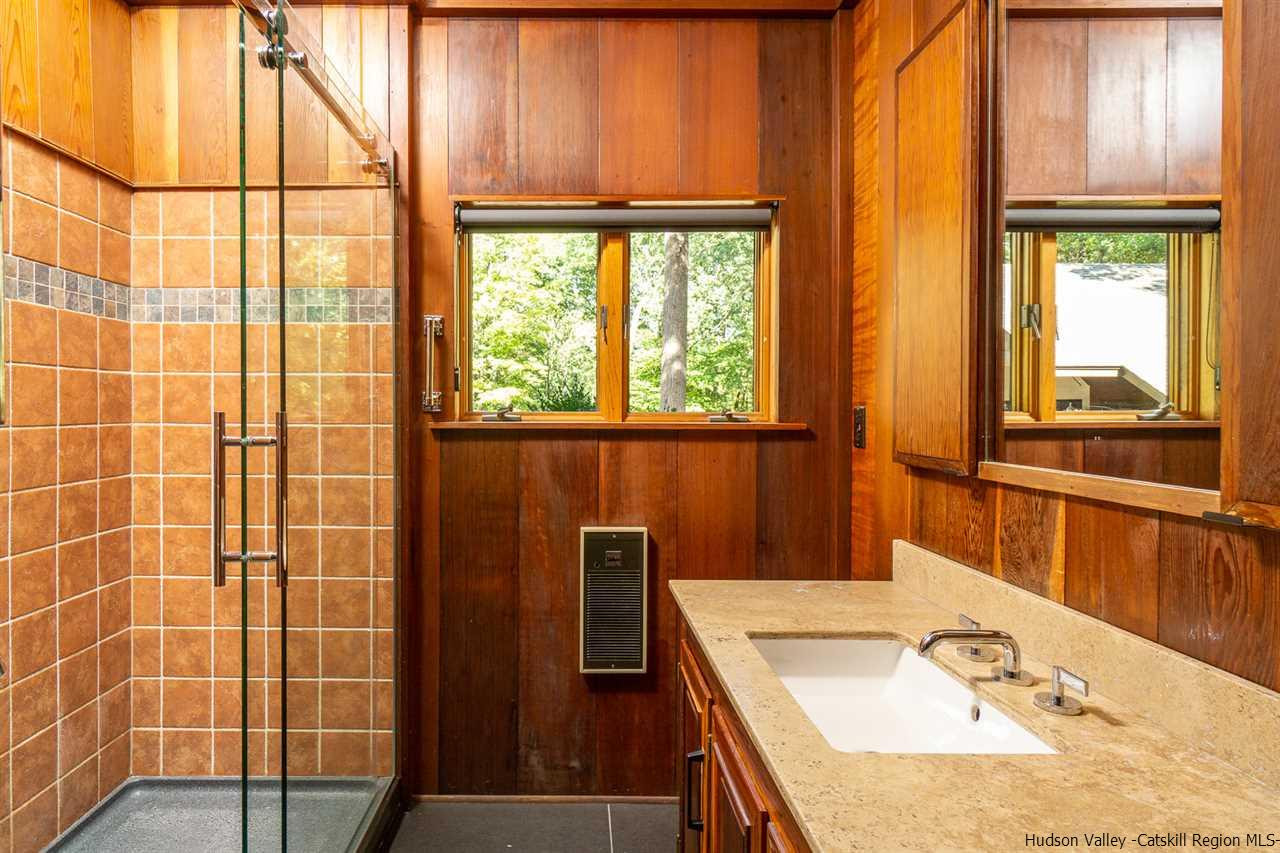 45 Pratt Road Stone Ridge, NY 12484 - Photo 30 of 35 a bathroom with a granite countertop sink a large mirror and a shower