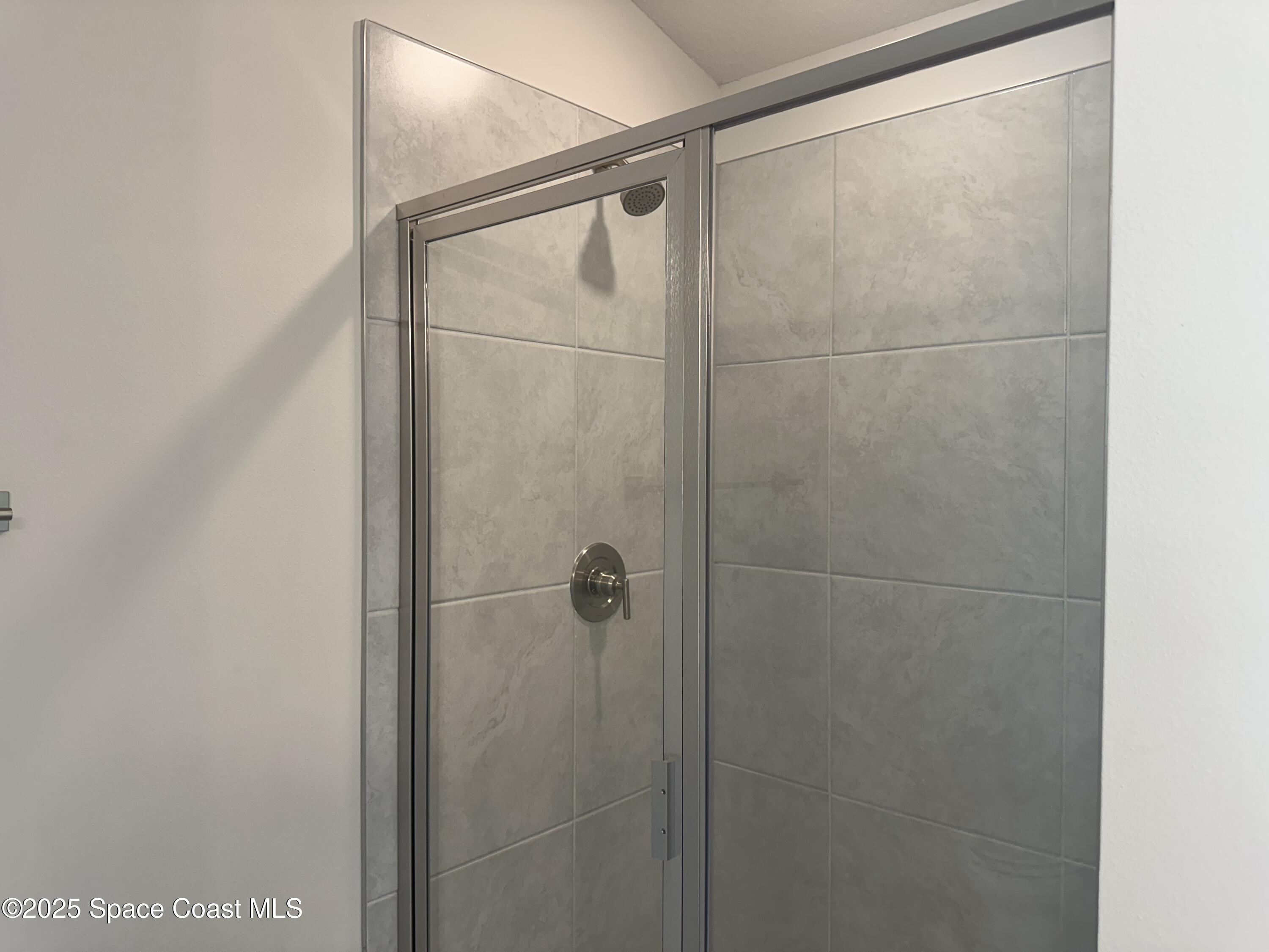 915 Kylar Drive Palm Bay, FL 32907 - Photo 14 of 15 a bathroom with a glass shower door