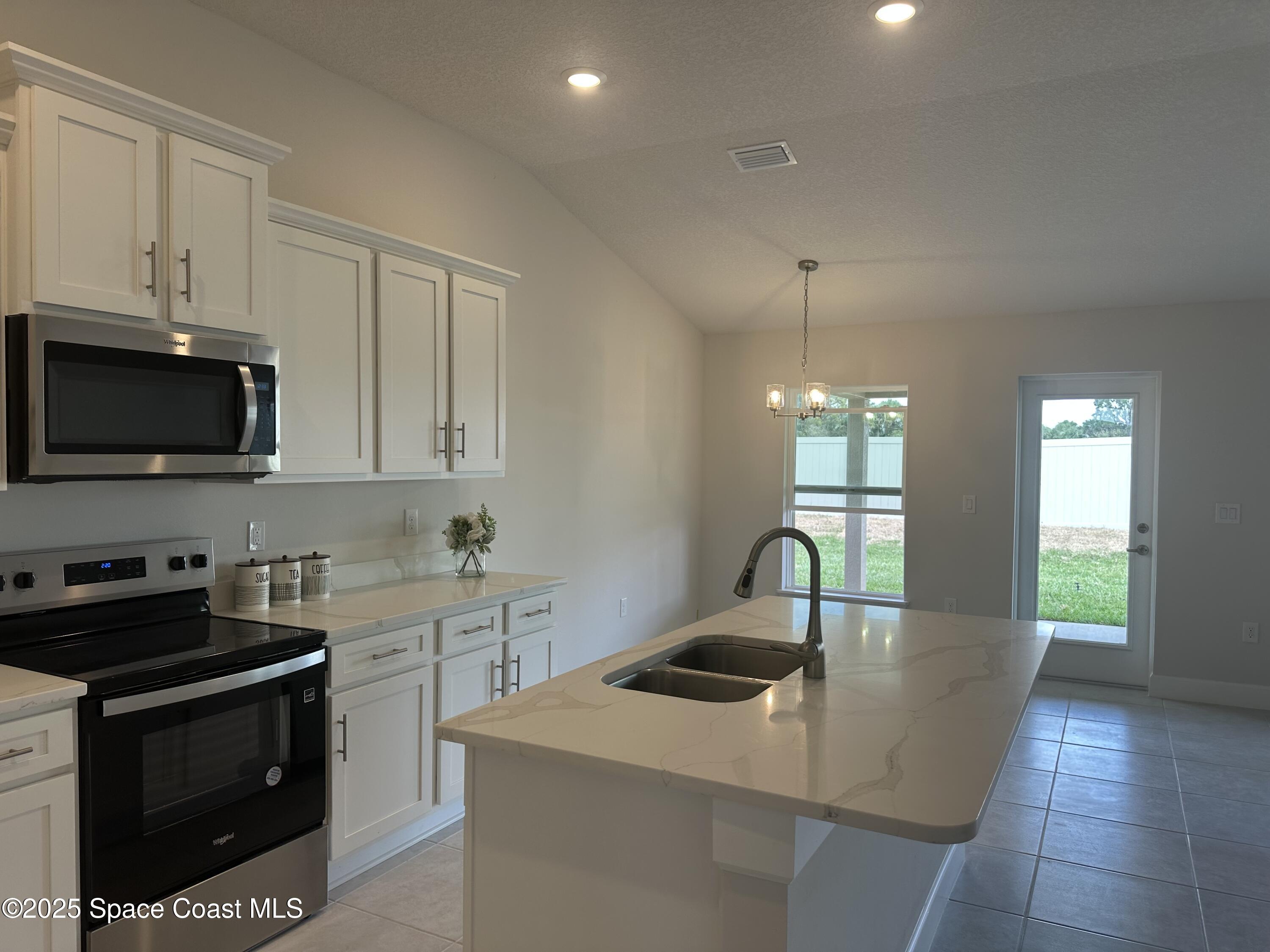 915 Kylar Drive Palm Bay, FL 32907 - Photo 4 of 15 a kitchen with stainless steel appliances granite countertop a sink a stove and a granite counter top