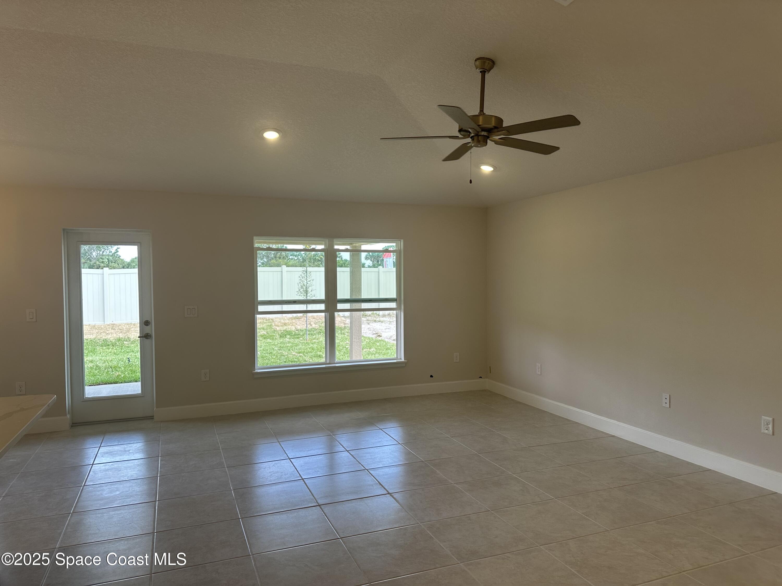 915 Kylar Drive Palm Bay, FL 32907 - Photo 7 of 15 an empty room with wooden floor and windows