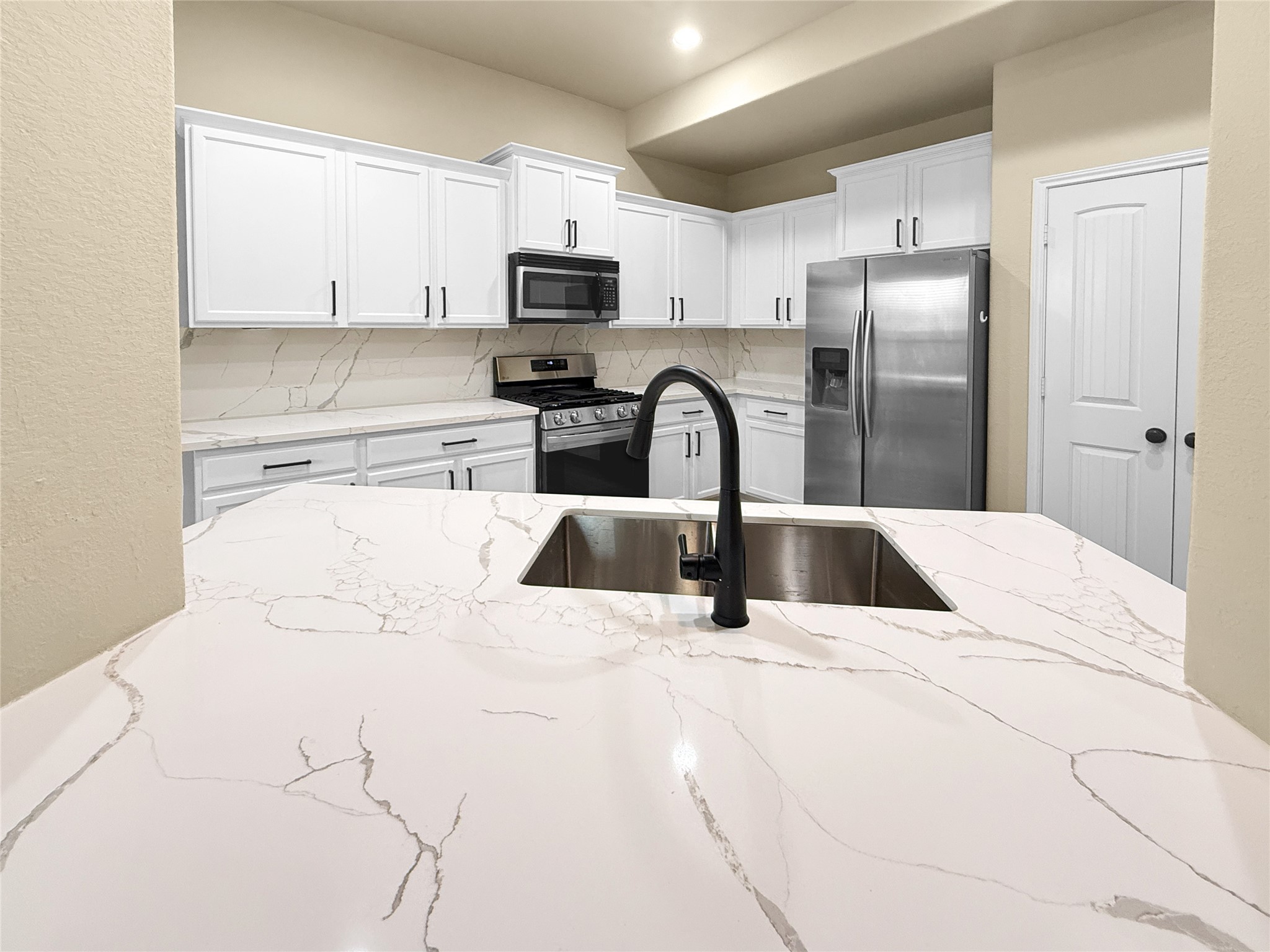 34 Hearthwick Road Tomball, TX 77375 - Photo 8 of 32 Quartz countertops and backsplash throughout the kitchen