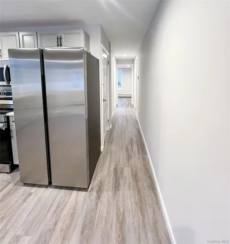 a view of a refrigerator in kitchen and wooden floor