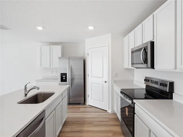 a kitchen that has a sink and a stove top oven