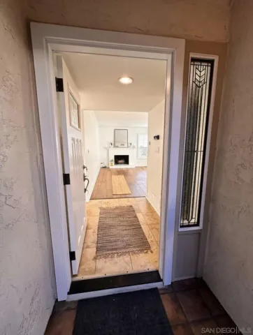 an empty room with furniture wooden floor fireplace and windows