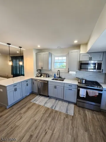 a large kitchen with stainless steel appliances sink a stove and cabinets