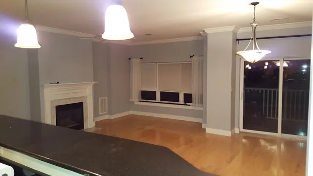 a kitchen with stainless steel appliances granite countertop a refrigerator a stove and a wooden floor