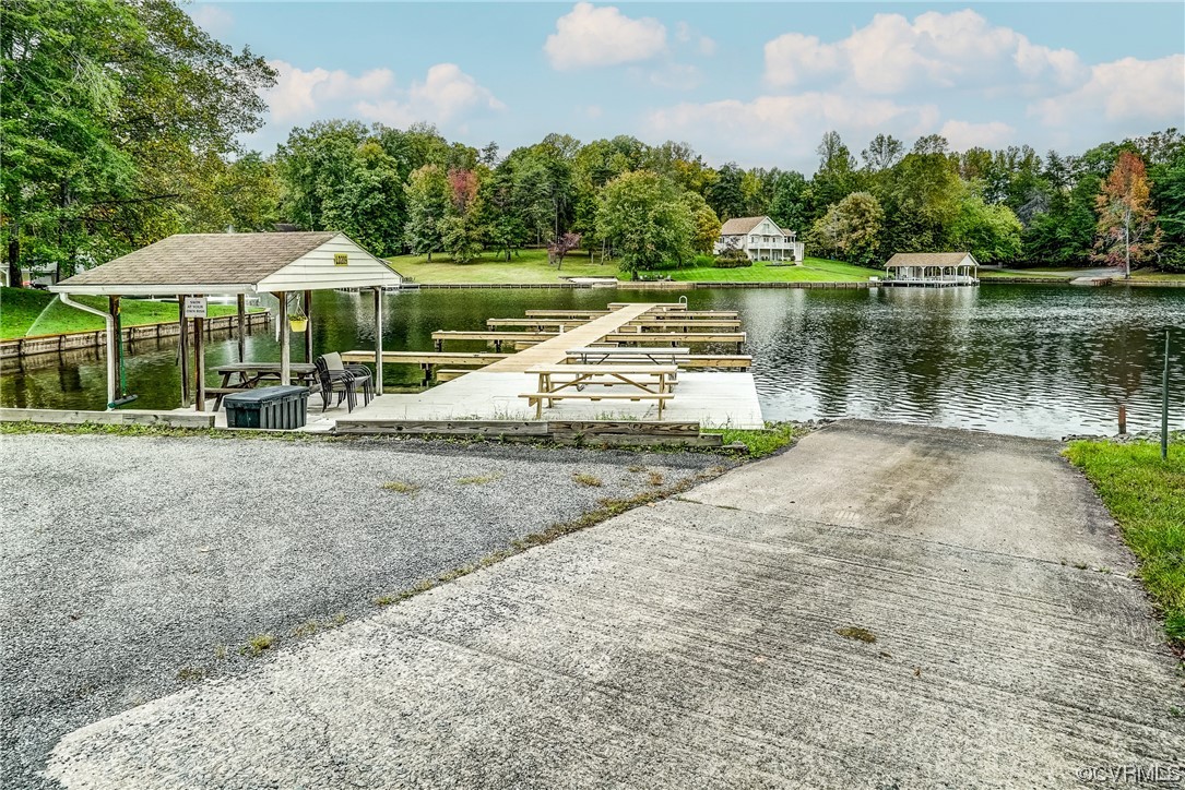 123 Plum Tree Circle Bumpass, VA 23024 - Photo 5 of 28 a view of a lake with a table and chairs under an umbrella