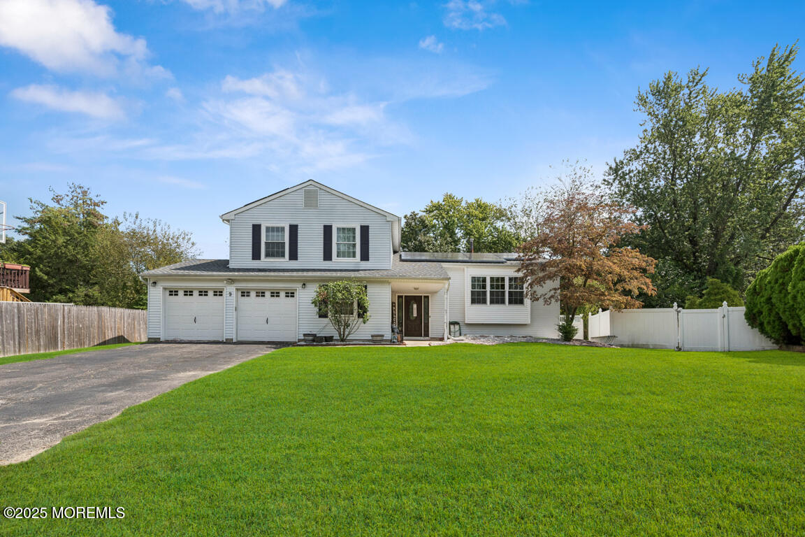 a front view of a house with a yard and trees