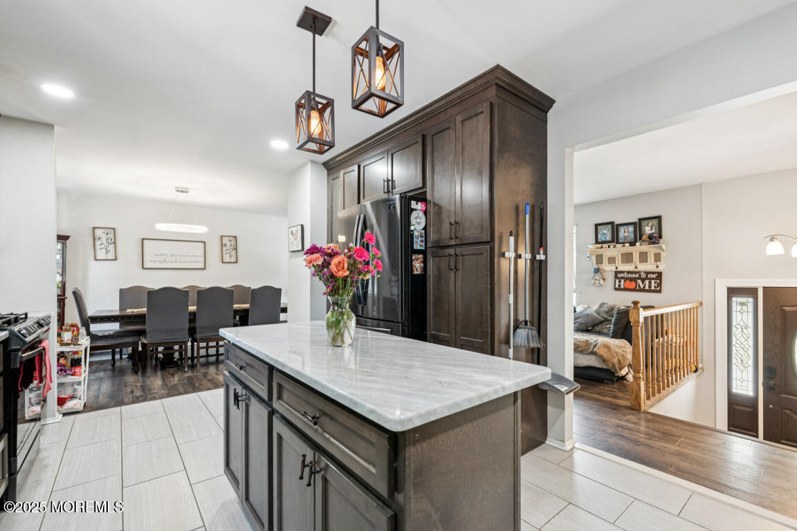 9 Cove Court Howell, NJ 07731 - Photo 20 of 20 a kitchen with stainless steel appliances kitchen island granite countertop a table chairs and a refrigerator