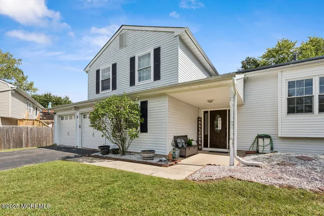 a view of a white house with a yard
